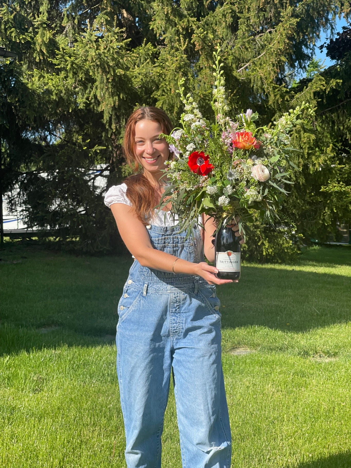 Noa holding a bouquet in a champagne bottle