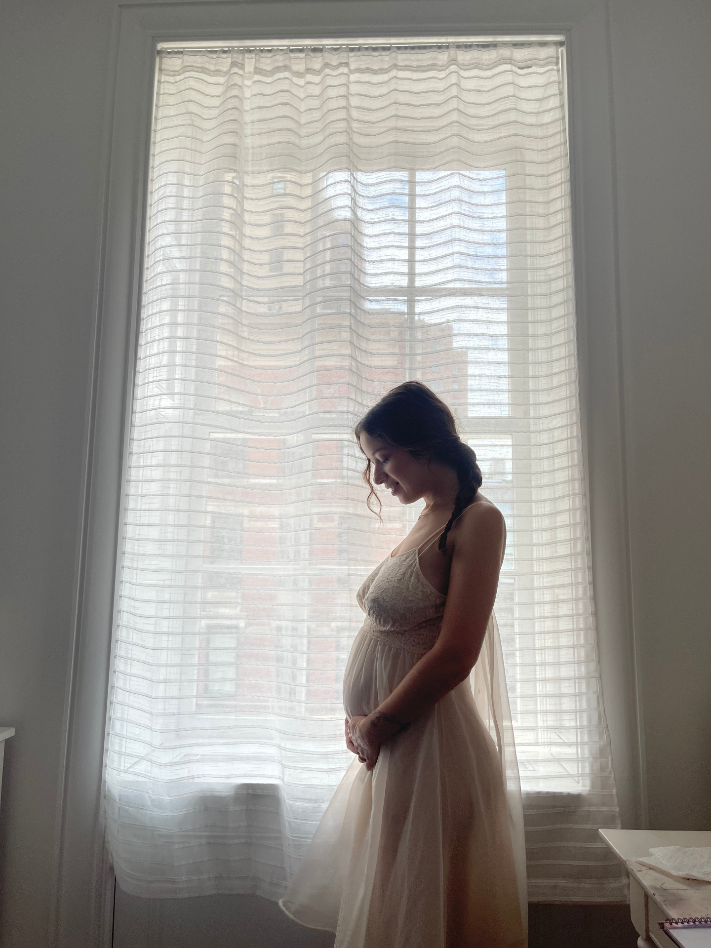 Noa standing in profile by a softly lit window