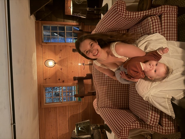 Noa laughing with Oren on a checkered couch