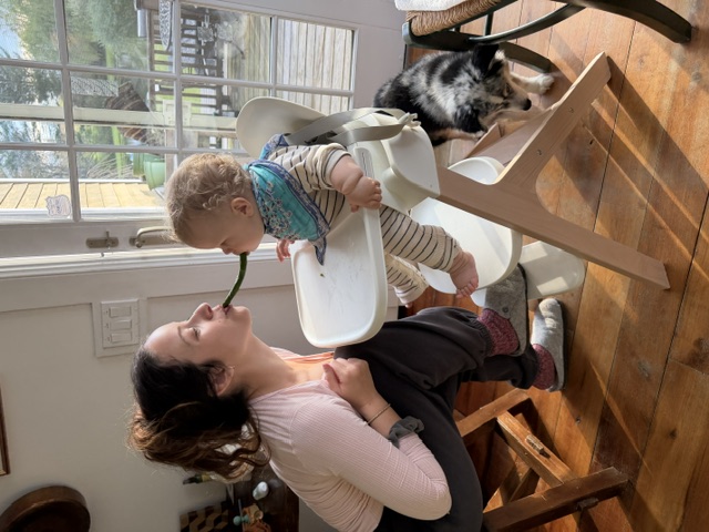Noa sharing greens with Oren in his highchair