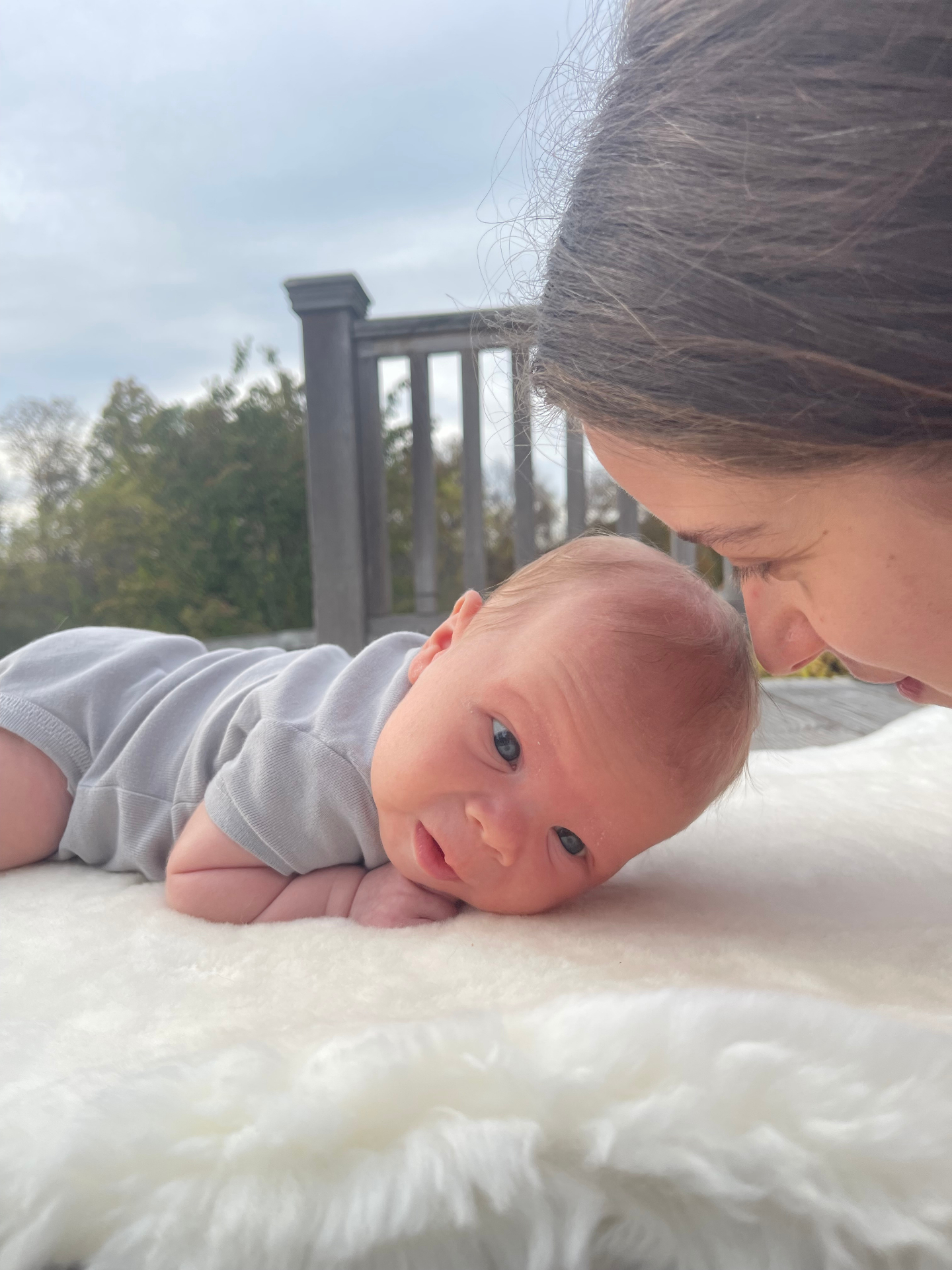Noa nose-to-nose with newborn Oren on a sheepskin