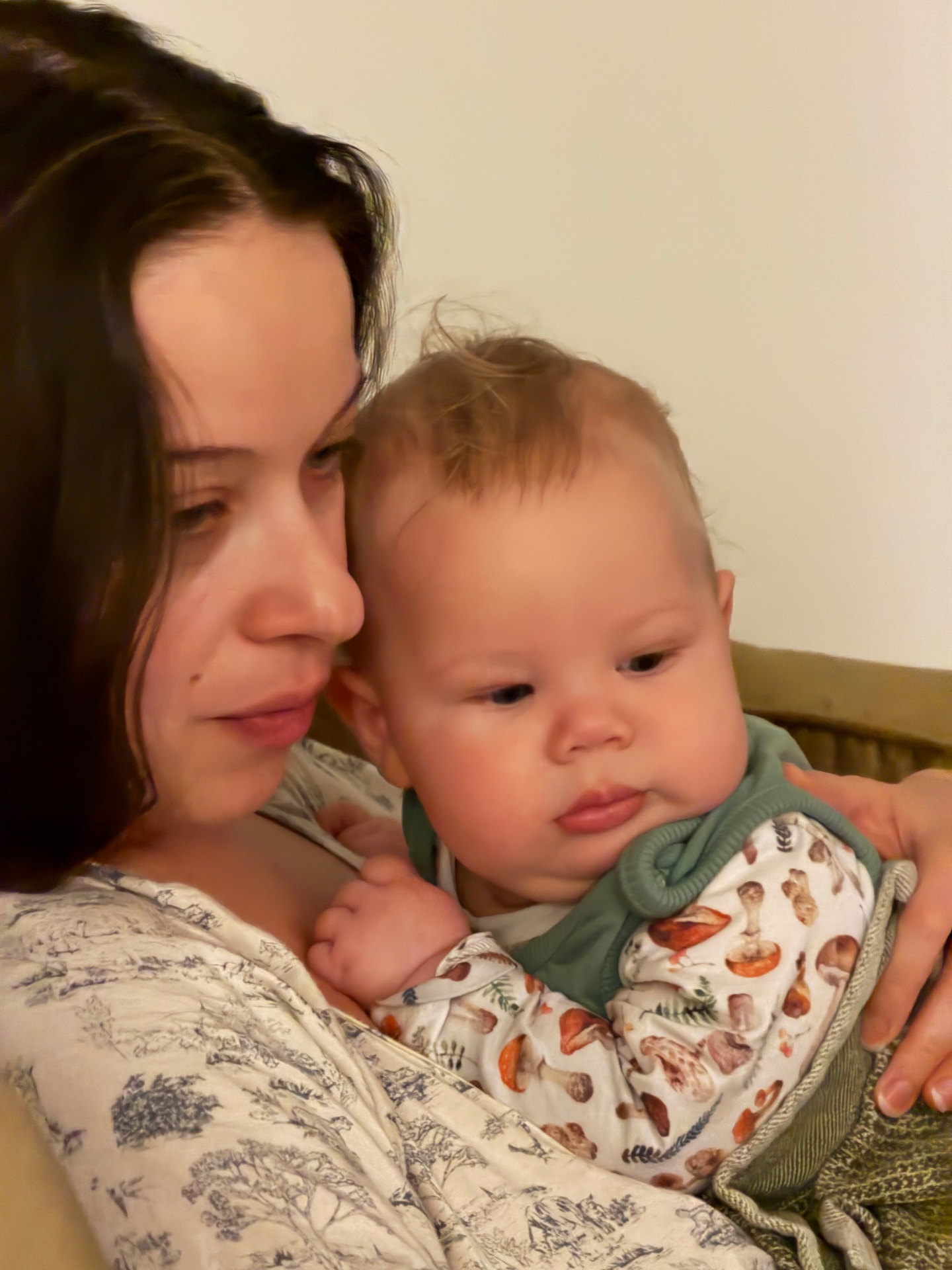 Noa holding Oren cheek to cheek in soft warm light