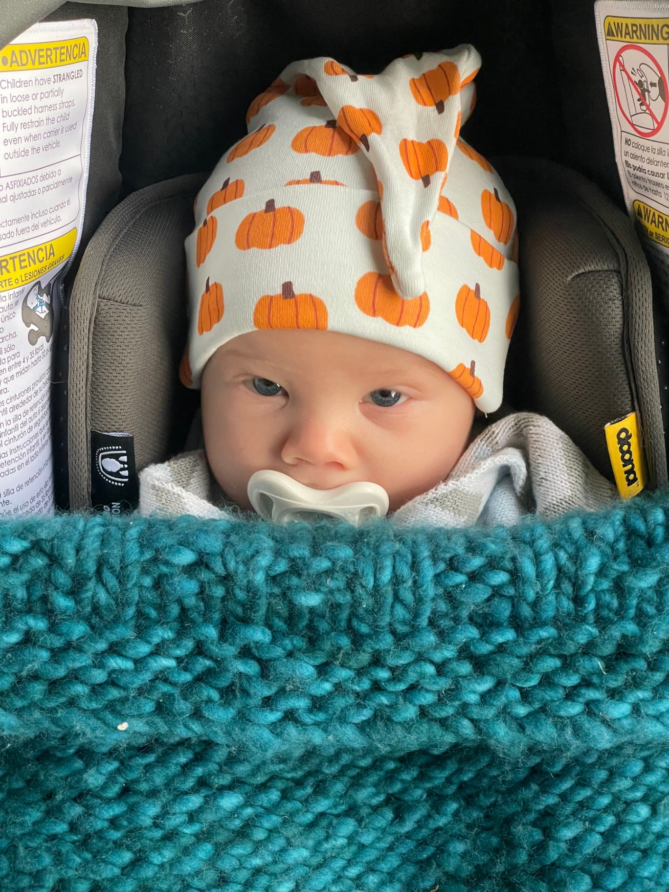 Oren in a pumpkin hat in his car seat